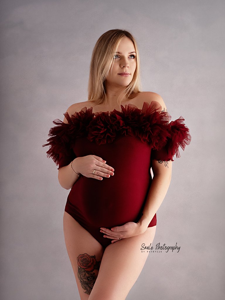 Mother-to-be posing for a natural maternity photoshoot with soft studio lighting